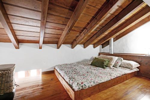 a bedroom with a bed with wooden ceilings and wooden floors at El Portillo 1 in Buenavista del Norte