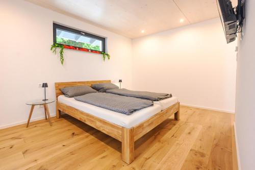 a bedroom with a bed and a window on the wall at Ferienwohnung Schwarzwald Penthus in Kappelrodeck