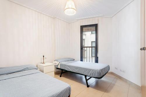 a bedroom with two beds and a window at Valencia Playa in Valencia