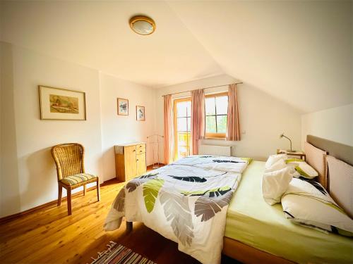 a bedroom with a bed and a chair and a window at Haus Rosenheim in Ramsau am Dachstein