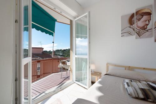 a bedroom with a balcony with a bed and a window at Bilocale Corosu con 2 balconi in Varazze