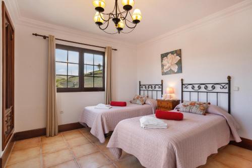 two beds in a room with a window at Finca Bellavista in Teguise