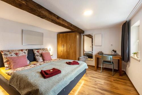 a bedroom with a large bed and a desk at Ferienhaus Mittendrin in Jesberg