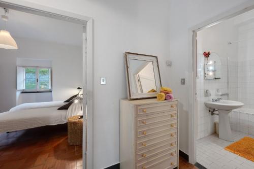 a white bathroom with a sink and a mirror at Agriturismo Monte Pu' in Castiglione Chiavarese