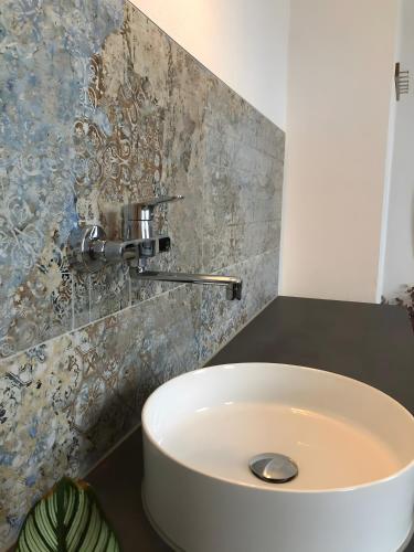 a white sink in a bathroom with a tile wall at Ferienzimmer Tübingen in Tübingen