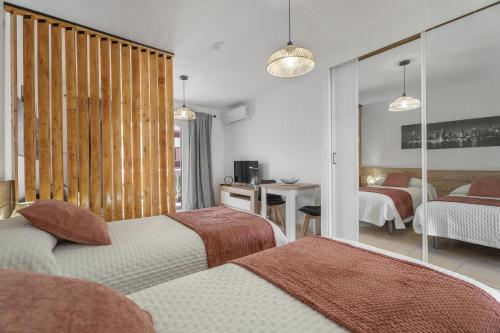 a hotel room with two beds and a mirror at Parque Carolina 208 in Costa Del Silencio