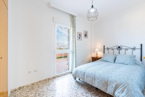 a bedroom with a bed and a window at Villa Cañete in Benamocarra