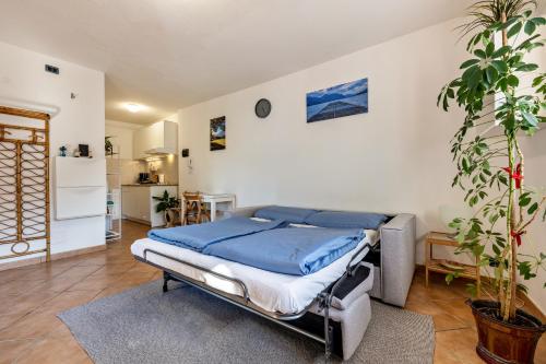 a bedroom with a bed with blue sheets on it at Panoramic Green Studio in Malcesine