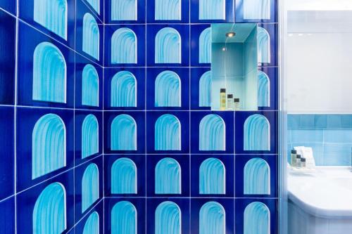 a bathroom with a blue tile wall with windows at Aurora Luxury Suites Seaview in Positano