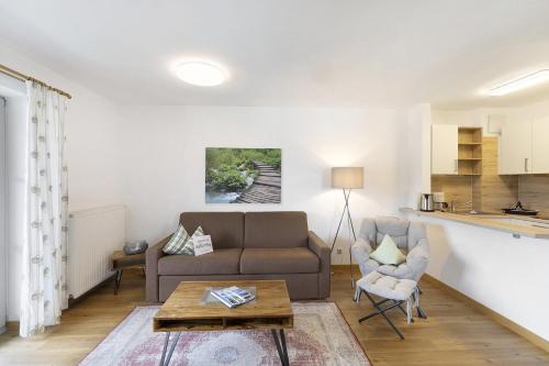 a living room with a couch and a table at Fewo Brünnstein - Nr 47 Pool, Sauna in Oberaudorf
