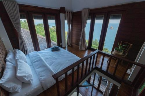 a bedroom with a bed with a view of the ocean at Blue Heaven Resort Koh Tao in Ko Tao
