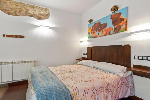 a bedroom with a bed and a painting on the wall at L de Alborada del Eo in Villameitide