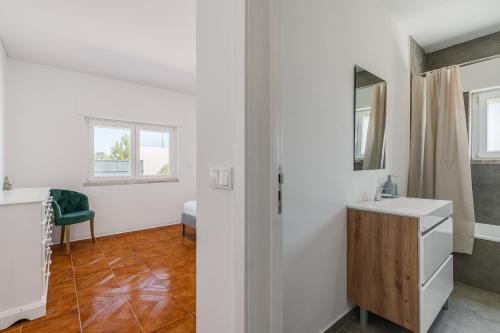a bathroom with a sink and a mirror at Palmela Sunset Villa in Quinta do Anjo