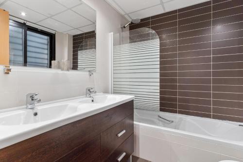 a bathroom with a tub and a sink and a bath tubermottermott at Hollywood A111 in Mijas Costa