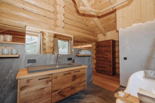a bathroom with a sink in a log cabin at Chalet Zwoasom in Grossarl
