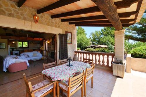 a patio with a table and chairs and a bedroom at Sa Vinyeta de Son Jaumell in Capdepera