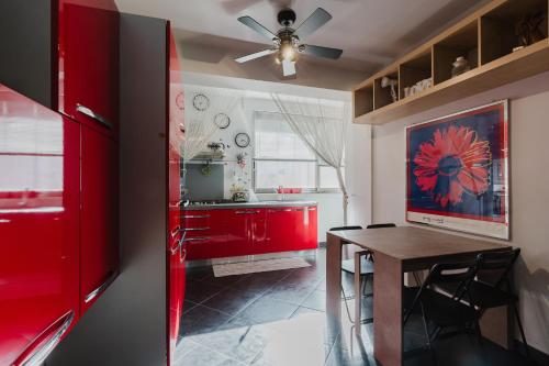 a kitchen with red cabinets and a wooden table at Casa Cuore in Marsala