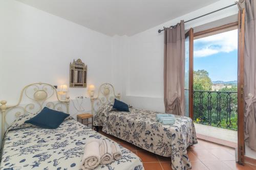 a bedroom with two beds and a balcony at Le Giare 2 in La Maddalena