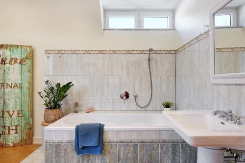 a bathroom with a bath tub and a sink at Ferienhaus Feldberg im Schwarzwald in Mittelfalkau