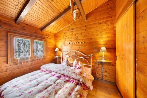 a bedroom with a bed in a log cabin at Orserose Chalet 1 La Bilancia in Forno di Zoldo