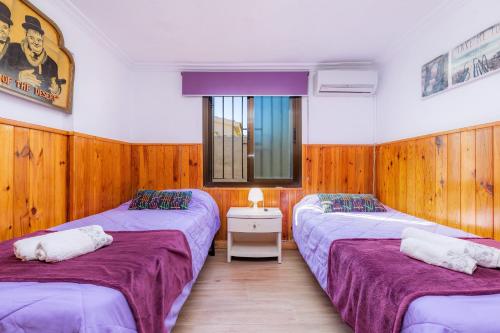 two twin beds in a room with wooden walls at Casa Paqui Alcudia in Port d'Alcudia
