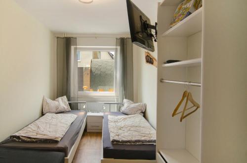 a small room with two beds and a window at Harzblick am Waldesrand in Hahausen