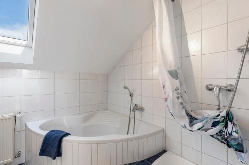 a white bath tub in a white tiled bathroom at Casa Di Napolitano 4 in Radolfzell am Bodensee