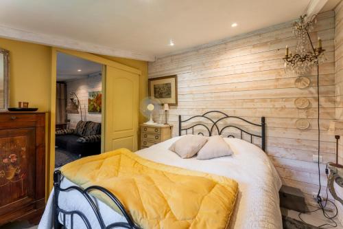 a bedroom with a bed with a wooden wall at Studio avec piscine à Avignon in Avignon
