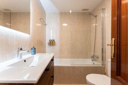 a bathroom with a sink and a tub and a toilet at Mirage Mijas centro in Mijas
