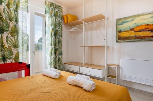 a bedroom with a yellow bed with towels on it at Helianthus in Cisternino