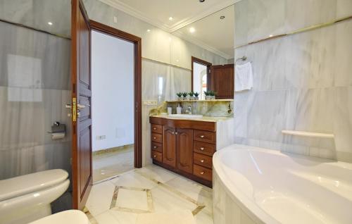 a bathroom with a tub and a toilet and a sink at Llum in Manacor