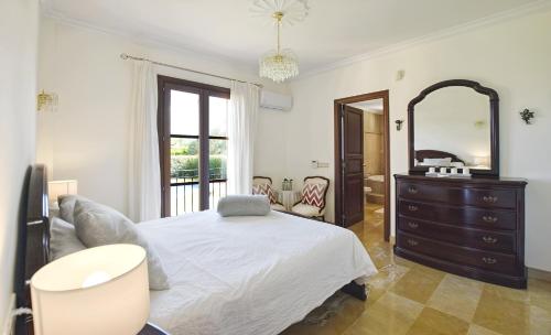 a bedroom with a bed and a dresser and a mirror at Llum in Manacor