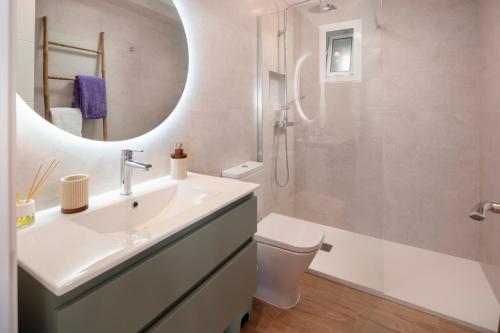 a bathroom with a sink and a toilet and a mirror at Marineros Sureste A111 in Torre del Mar