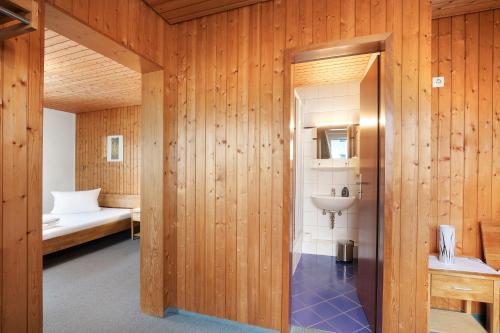 a bathroom with a bed and a sink in a room at Hotel Garni Siedlerstube in Nürtingen