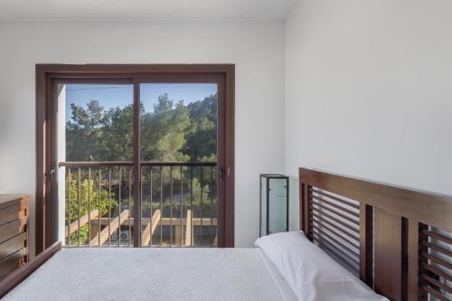 a bedroom with a bed and a large window at Villa Retreats in Santa Eularia des Riu