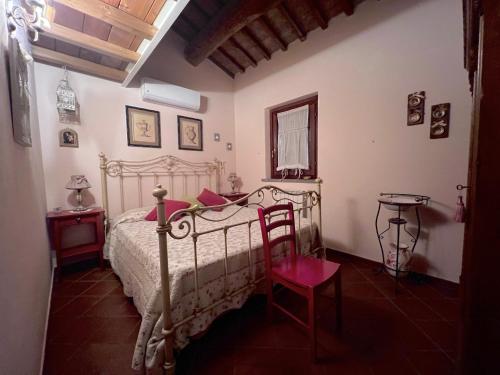 a bedroom with a white bed and a red chair at Il Forcone in Panicale