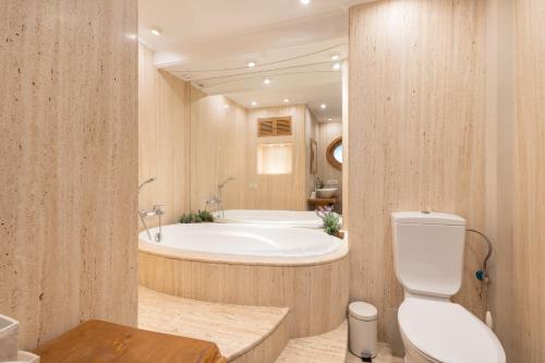 a bathroom with a bath tub and a toilet at Mas Juli in Pineda de Mar