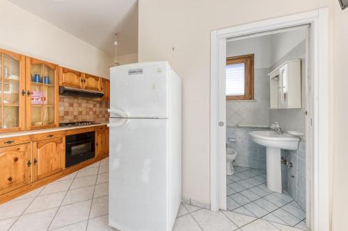 a white refrigerator in a kitchen with a sink at Rocco 1 in Torre San Giovanni Ugento