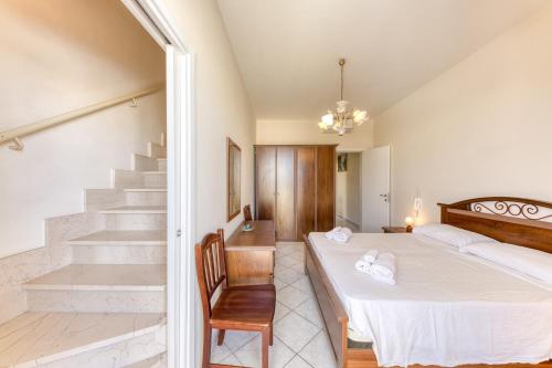 a bedroom with a bed and a chair and a staircase at Rocco 1 in Torre San Giovanni Ugento