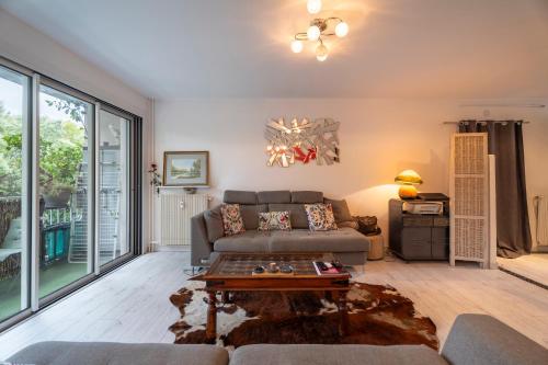 a living room with a couch and a table at Appartement Atypique avec terrasse in Hyères
