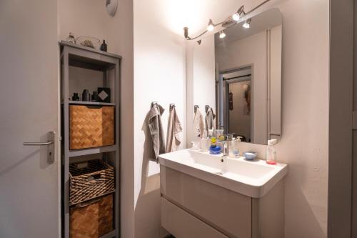 a white bathroom with a sink and a mirror at Appartement Atypique avec terrasse in Hyères