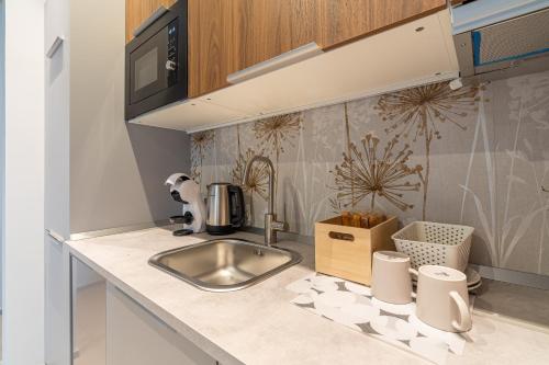 a kitchen counter with a sink and a microwave at Bellini House in Viagrande