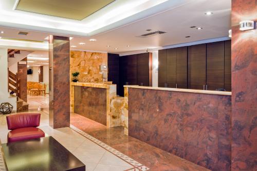 a lobby of a hotel with a bar and a chair at Akrata Beach Hotel in Akrata