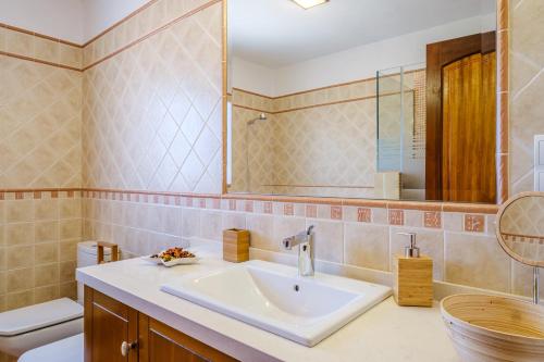 a bathroom with a sink and a toilet and a mirror at Casa Cristina Ibiza in Sant Carles de Peralta