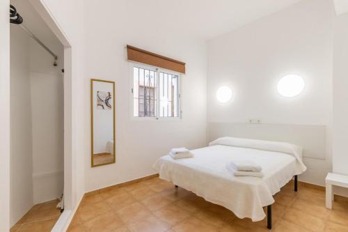 a white room with a bed and a window at Entreplayas Benidorm in Benidorm