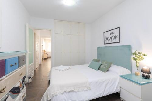 a bedroom with a white bed and a blue headboard at Fidalsa Relax Pool your Refuge in Torrevieja