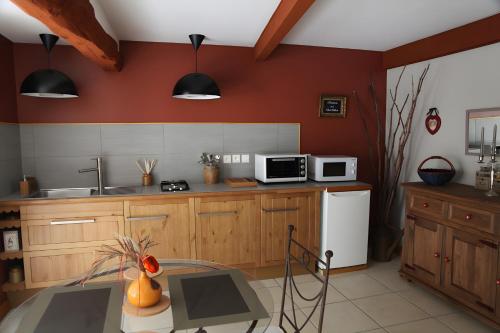 a kitchen with wooden cabinets and a white refrigerator at Gite Les Trois Collines in Cuisiat