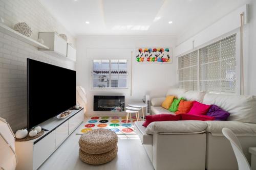 a living room with a couch and a flat screen tv at Casa Margara in Chipiona