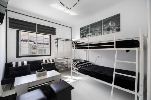 a living room with two bunk beds and a couch at Casa Margara in Chipiona