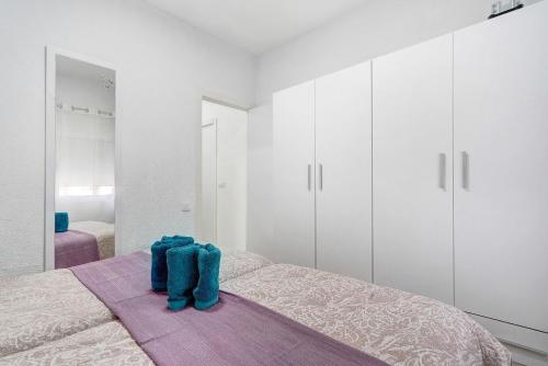 a bedroom with white cabinets and blue shoes on a bed at Un descanso 2 in San Fernando